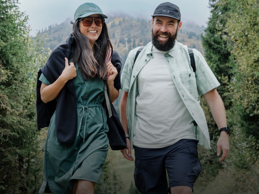 Young woman in sporty hiking gear crouches on a rock in the&nbsp;darkness