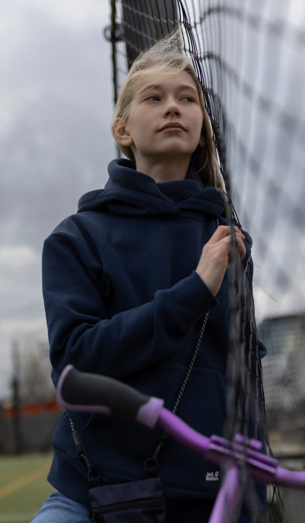 Girl leaning against a fence